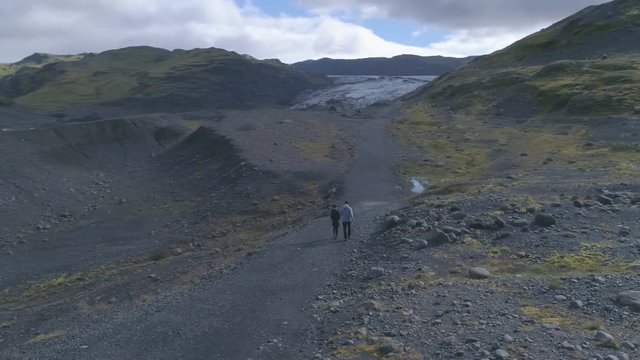 Aerial of couple hiking to explore glacier in Iceland
