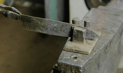 Making the knife out of metal at the forge. Alignment of the knife blades after hardening of the metal.