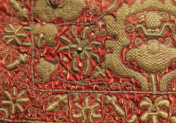 Vintage hand embroidery - golden floral pattern on red background