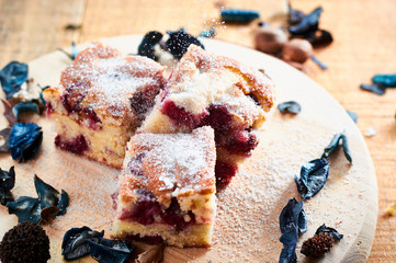 Delicious cake with cherries on wooden table