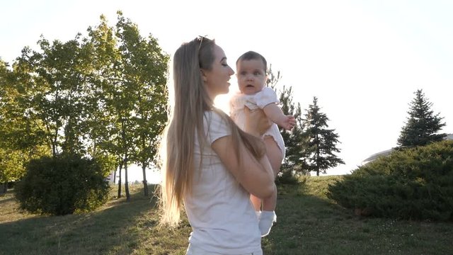 Slow motion of mother and daughter in flare sunset. Concept of happy family