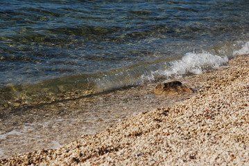 Kiesstrand mit Welle