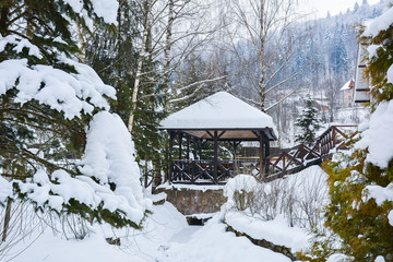 Winter landscape. Snow-covered winter town against background of mountainside with spruce forest. City in the mountains, Yaremche, Ukrainian Carpathians.