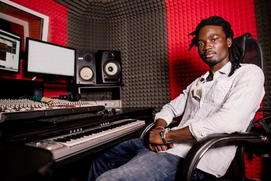 African musician with dreads sitting in a recording Studio