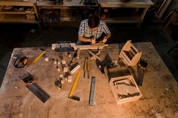 Carpenter craftsman makes joinery in the workplace top view