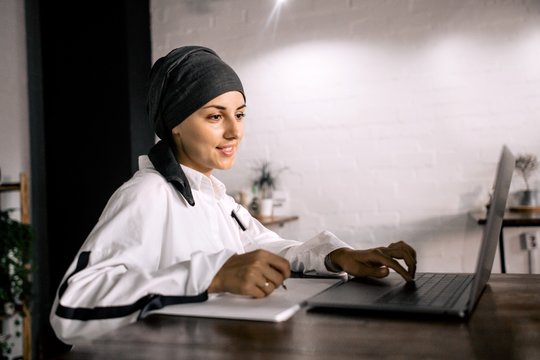 Georgian girl working in the office for a laptop making notes in a notebook