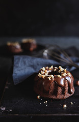 Mini chocolate bundt cakes topped with glaze and hazelnuts