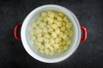 Raw gnocchi in the water preparing for cooking,selective focus