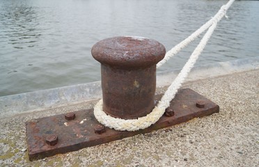 Rusty bollard and ship rope on the pier © Victor