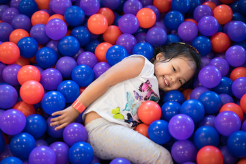 Fototapeta na wymiar Asian little girl enjoys playing in a children playground