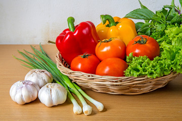 Organic vegetables in the wicker basket on wooden background