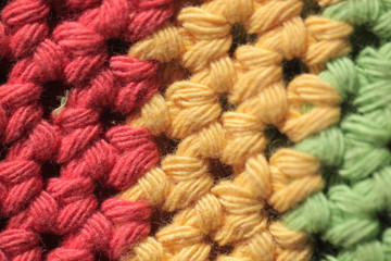 colorful background - macro photography of knitted wool structure in red, yellow and green