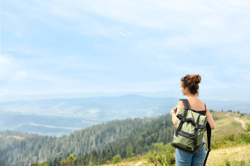Fototapeta premium Woman with backpack in wilderness on cloudy day