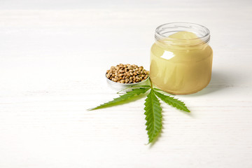 Composition with hemp lotion and space for text on white wooden background