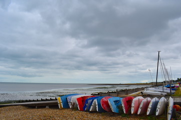 Colourful boats for hire on the Whitstable pebbled beach. Whitstable, Kent, UK