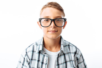 Fototapeta premium Portrait of beautiful boy with glasses, teen nerd smiling, in Studio on white background