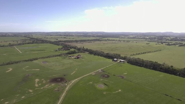 An aerial view of a farm and farm buildings near a road in Nar Nar Goon outside of Melbourne, Victoria, Australia.