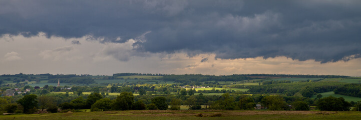 Fototapeta na wymiar Purple Grey Skies and Green English Countryside Panorama