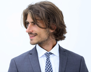 Handsome man in stylish clothes is looking away and smiling