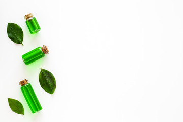 Tea tree essential oil near tea tree leaves on white background top view copy space