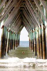 Under a pier on the Atlantic Ocean, Sunset Beach, North Carolina, showing the structure of the pilings and support structure