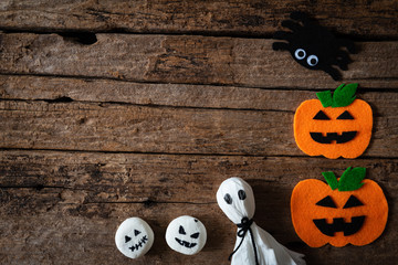 Top view of Halloween crafts, orange pumpkin, ghost and spide on wooden background with copy space for text. halloween concept.