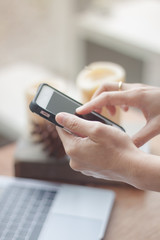 Woman using smart phone in coffee shop