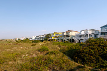 Fototapeta na wymiar Vacation beach rentals on the green sand dunes, Sunset Beach, North Carolina