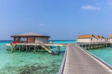 Maldives, Feb 8th 2018 - A part of the Cestara hotel over the blue water beach, calm waters in the lagoon in a clear sky in Maldives