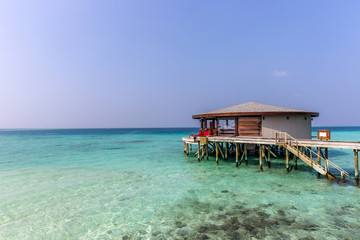 Maldives, Feb 8th 2018 - A part of the Cestara hotel over the blue water beach, calm waters in the lagoon in a clear sky in Maldives