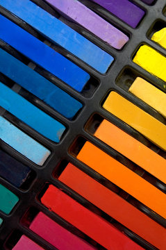Vertical Image of Colorful Pastel Crayons and Book