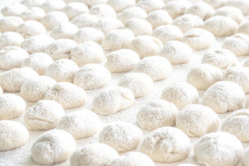 Selective focus of dough balls on white wooden board