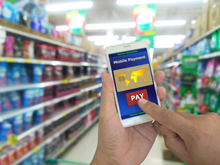 Fototapeta na wymiar mobile payment, Male hands using smartphone confirms payment by credit card for online payment in supermarket, A digital wallet to pay for goods and services to convenient and fast. Business concept.