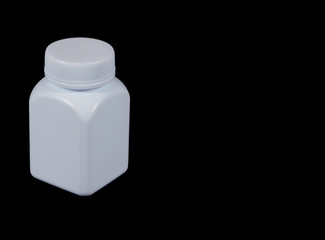 White plastic medicine bottle isolated on black background