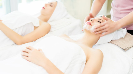 Obraz na płótnie Canvas Woman lying in bed relaxing in spa.Woman is lying on the spa bed to do a facial scrub.Spa facial massage in beauty salon.
