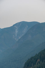 layered mountains with peaks under the heavy smoke in the morning 