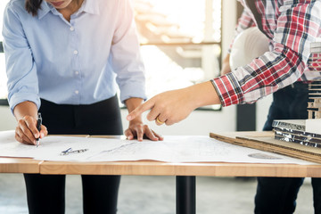 Close-up Of Person's engineer Hand Drawing Plan On Blue Print with architect equipment, Architects discussing at the table, team work and work flow construction concept