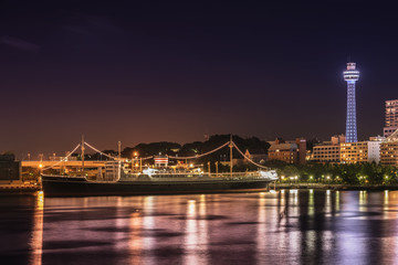 Old cruise ship Hikawa Maru with big masts and a big chimney with the MarineTower in background in the Minato Mirai district of Yokohama.