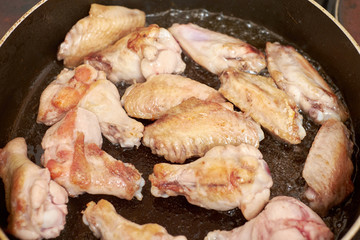 Chicken wings fried in pan with hot oil, homemade food