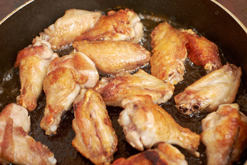 Chicken wings fried in pan with hot oil, homemade food