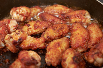 Chicken wings fried in pan with hot oil, homemade food