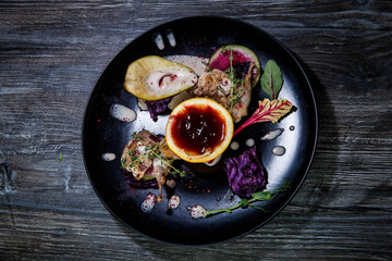 top view of tasty decorated meal on black restaurant plate