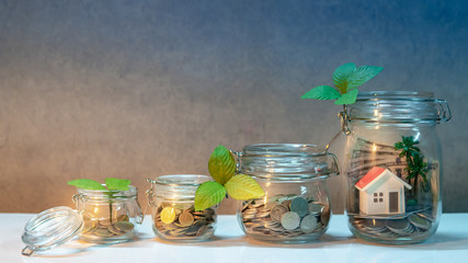 Saving money for retirement. Property or real estate investment. Home mortgage loan rate. Coins, dollar banknotes, credit card and house model in glass jars on the table. Financial growth concept