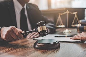 Judge gavel with Justice lawyers having team meeting at law firm background. Concepts of Law and Legal services.