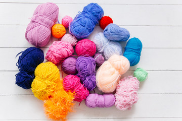 top view of colored yarn balls and knitting needles