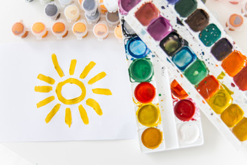 Set of watercolor paints and paintbrushes on a table