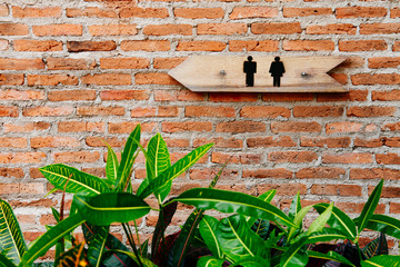 Wooden toilets sign on old brick wall