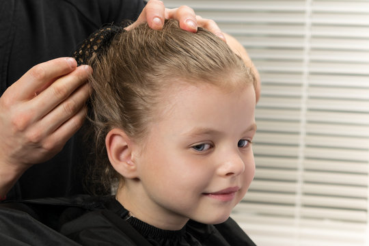 hair stylist fixes with a hairpin hairstyle for a girl