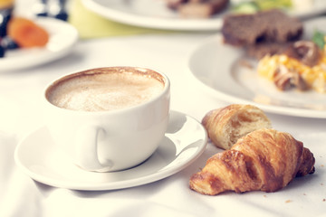 Coffee and croissant for breakfast with shallow depth of field.