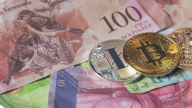 Physical metal Bitcoin currency over bolivar bills. Virtual internet money with Venezuelan banknotes. Digital coin cyberspace, cryptocurrency. BTC golden coin as symbol of electronic virtual money. 4K